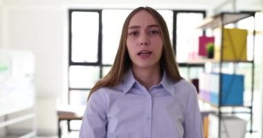 İş kadını ofiste yürürken kameraya konuşur. Başarılı, katı iş kadını blogcusu kameraya konuştu