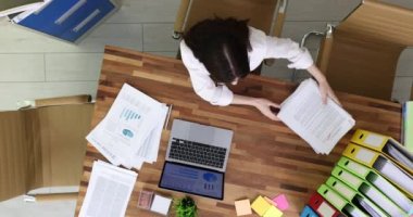 Ofiste masa başında çalışan hayal kırıklığına uğramış bir iş kadını iş görüşü için bir sürü belge veriyor. Geç saatlere kadar çalışmaktan yorgun ve başım ağrıyor.