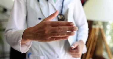 Kadın bir el sıkışmak için elini uzatıyor, sığ bir odak noktası. Klinikte selamlar, Bakımevinin dost canlısı personeli.