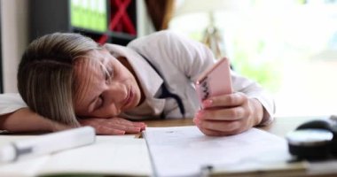 Yorgun bir kadın doktor akıllı telefona bakar, yakın plan, yavaş çekim. Kronik yorgunluk sendromu kavramı