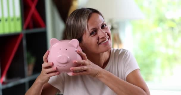 Mulher Feliz Sacude Porquinho Perto Orelha Perto Conceito Acumulação Fundos — Vídeo de Stock