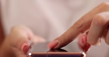 Kadınların parmakları akıllı telefon ekranını kaydırıyor, yakın plan. Telefondaki uygulamayı kullanarak, sığ odak