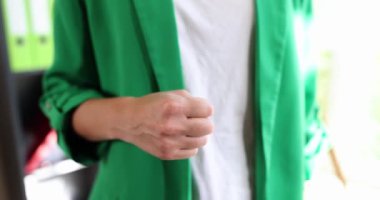 Ofiste dikilen bir kadın bir zafer jesti sergiliyor, yakın çekim. Barışçıl ilişkiler için iş desteği kavramı