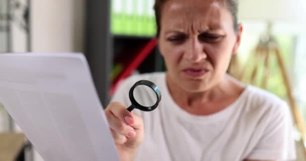 Seorang Wanita Membaca Dokumen Melalui Kaca Pembesar Close Fokus Dangkal — Stok Video
