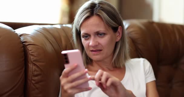 スマートフォンの画面 クローズアップから読んでソファの上の女性 行動中毒の概念は 電話で休む — ストック動画