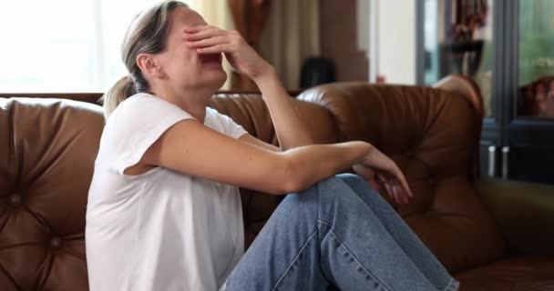 ソファの上に座っている女性はひどく クローズアップ スローモーション泣いている 感情的苦痛悲しみ — ストック動画