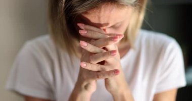 Kadın başını eğdi ve ellerini yüzüne koydu, yakın çekim, yavaş çekim. Tanrı için duayı kabul et.