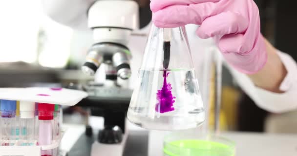 Wissenschaftler Chemiker Tropft Rosa Flüssigkeit Glaskolben Mit Wasser Labor Nahaufnahme — Stockvideo