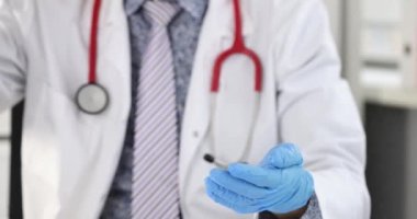 Klinikte elinde lastik eldivenlerle antiseptik tüttüren adam 4K yavaş çekim. Covid19 salgını sırasında sağlık personeli için hijyen kuralları