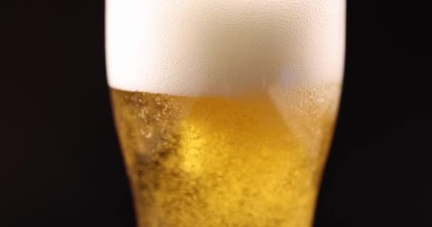 泡でガラスに注ぐ黄金のビールと多くのガス泡が4K映画スローモーションを閉じます アルコール依存症の概念 — ストック動画