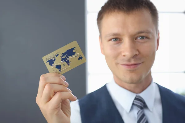 Smiling businessman holds plastic bank card in his hand. Development of the banking sector and services to the population concept