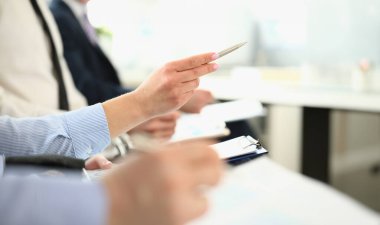 Yeni iş projesini tartışan dost canlısı meslektaşlarına odaklan. Büyük, modern ofis binasında kalem tutan güzel bir kadın. Şirket toplantısı konsepti. Bulanık arkaplan