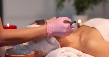 Spa therapy for woman and receiving black face mask. Rejuvenation and skin care concept