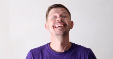 Young handsome smiling mentally ill man waving knife. Mental disorder and threats concept