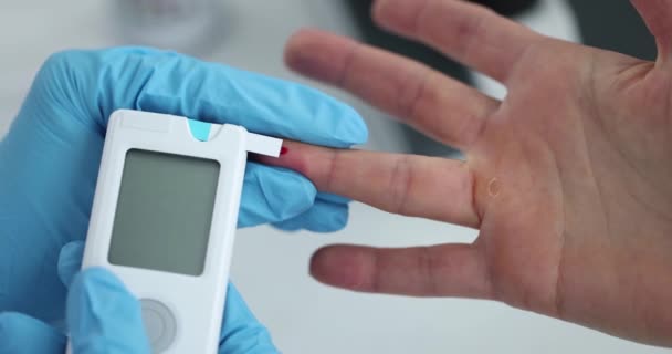 患者の血糖値を測定するゴム手袋の医師は クローズアップ4K映画スローモーションを使用して 糖尿病の概念の診断と治療 — ストック動画