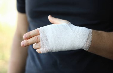 Kolu sıkı, elastik bandajlı bir erkek eli. Kişisel yardım burkulma kavramı