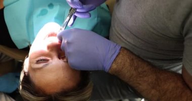Dişçi kadın diş etlerine anestezi ilacı enjekte ediyor. Diş hekimliğinde diş anestezisi