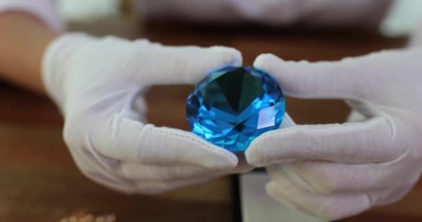 戴手套的珠宝商的手拿着大的圆形蓝色钻石 石料检查 — 图库视频影像