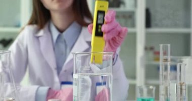 Dijital su testi ve su analiz teknolojisi. Dijital pH ölçer ve analizci bilim adamı laboratuvar asistanının ellerinde.