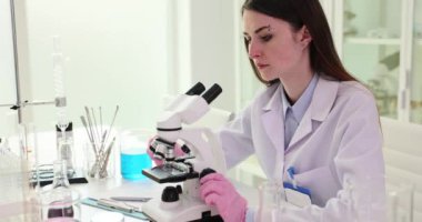 Bilim adamı modern mikroskop ve laboratuvar deneyleri kullanıyor. Biyolog genetikçi madde örneklerini inceliyor