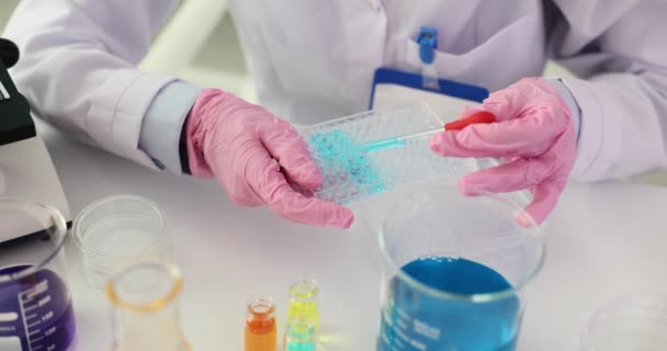 科学者は ブルー液体を実験室の試験管容器に配置する 実験室で有毒な有毒溶剤をテストする — ストック動画