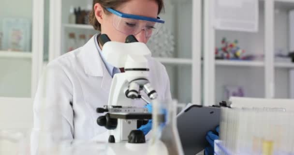 Biologische Wetenschapper Laboratoriumassistent Kijkt Door Microscoop Schrijft Medisch Rapport Aan — Stockvideo