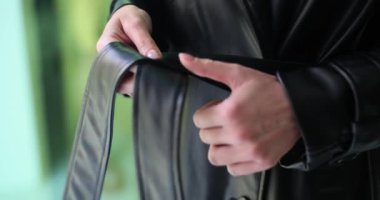 Kadın iki eliyle siyah deri ceketi sıkıyor. Sonbahar modaya uygun giysiler ve kaliteli paltolar.
