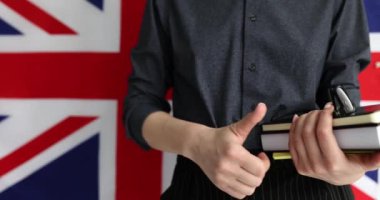 Yabancı bir kadın başparmağını kaldırıyor ve İngiliz bayrağı taşıyor. Londra 'da onaylanmış ve tavsiye edilen eğitim