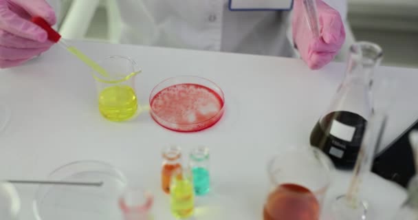 실험실에서 일하는 과학자는 물질과 페트리 접시에 노란색 액체를 뜨린다 — 비디오