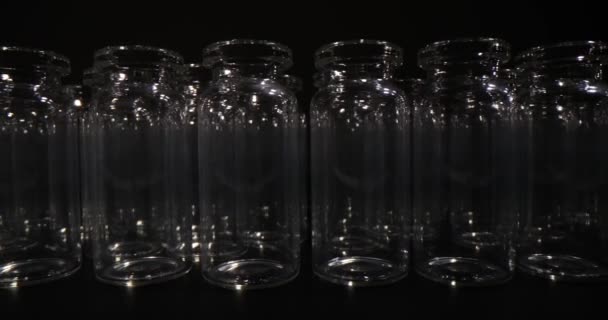 黑色底座疫苗生产和包装用的一排排空玻璃瓶 医用玻璃器皿 — 图库视频影像
