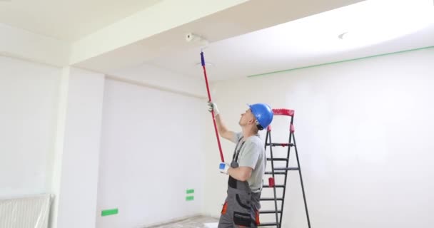 人在明亮的房间里用胶辊把天花板涂成白色 修理和油漆 — 图库视频影像