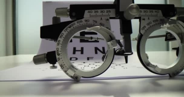 试车架 眼图测试和白色木制桌子上的眼镜 眼科医生工具 — 图库视频影像
