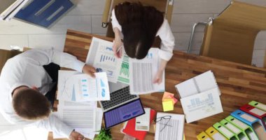 Ofis masasında oturan iki ciddi iş adamı bir projeyi tartışıyor. Sunum yapan, büyümeyi analiz eden ve pazar grafiklerini inceleyen yöneticiler