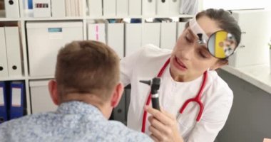 KBB doktoru hastaya otoskopla tıbbi muayene yapar. Yetişkinler konseptinde işitme testi