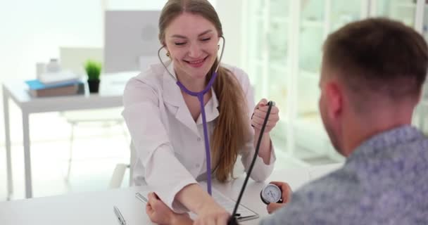 Pielęgniarka Dodatnia Mierzy Ciśnienie Tętnicze Męskiego Pacjenta Sfigmomanometrem Podczas Badania — Wideo stockowe