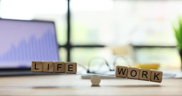 生活与工作写在木制立方体上 在轻便办公室的工作场所天平上保持平衡 平衡工作与私人生活的概念慢动作 — 图库视频影像