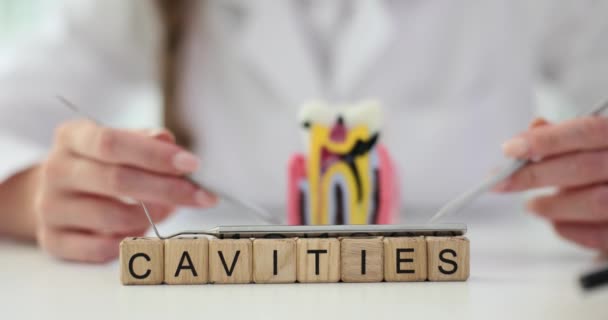 Слово Cavities Деревянных Блоков Столе Врача Помещении Осмотра Стоматолог Указывает — стоковое видео