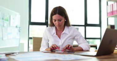 Kadın işçiler müşterilerine akıllı telefondan hesaplamalar yaparlar. Yönetici, iş projesini potansiyel müşteri konseptine hazırlıyor