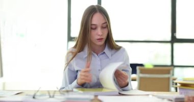 Genç bayan pratik derslere hazırlanmak için ders defterine bakıyor. Kız öğrenci üniversitede seminer için bilgi öğreniyor