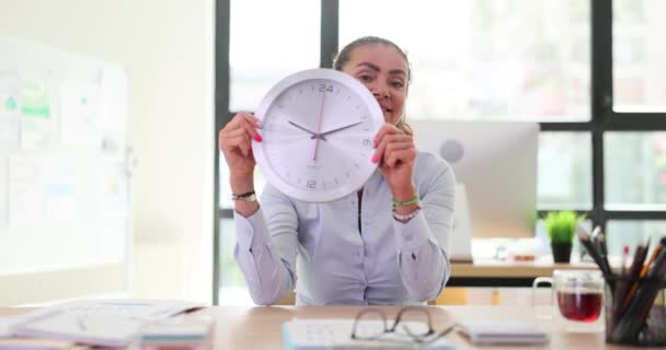 Счастливая Работница Компании Держит Настенные Часы Указывающие Окончание Рабочего Дня — стоковое видео