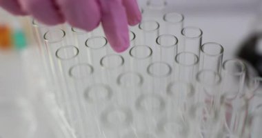 Lastik eldiven takan laboratuvar çalışanı klinikte araştırma yapmak için boş tüp alıyor. Klinikte yavaş çekimde kontrol ve analiz