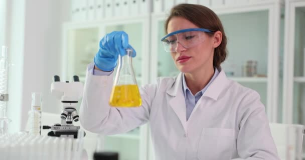Vrouwelijke Laboratoriummedewerker Met Veiligheidsbril Heeft Een Monster Van Reagens Lichtkliniek — Stockvideo