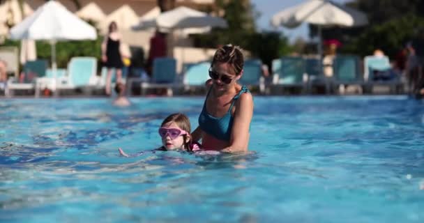Madre Concentrada Enseña Hija Nadar Piscina Del Parque Acuático Adquirir — Vídeos de Stock