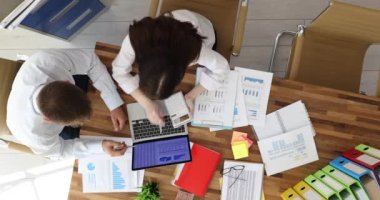 Ofis çalışanları şirket promosyon projesini tartışırken dizüstü bilgisayara bakıyorlar ve kar tabloları ahşap masada. İş toplantısı. İş yerinde takım çalışması