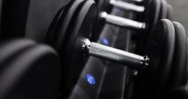 Spor kulübünde fiziksel sağlığı ve dayanıklılığı arttırmak için çok sayıda siyah dambıl. Spor salonundaki profesyonel sporcular için spor malzemeleri.