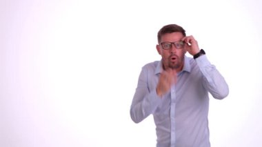 Beyaz stüdyo duvarında, erkek ofis çalışanı anlaşmazlık içinde başını sallıyor. Kafası karışmış sakallı adam sessizce gözlüğünü çıkartıyor.
