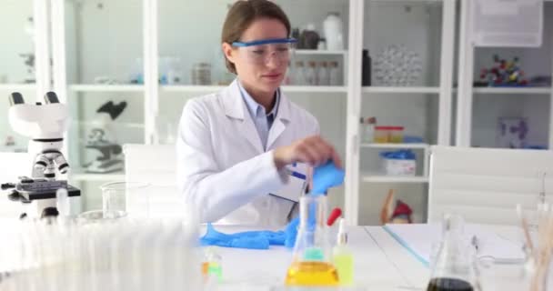 과학자는 현미경과 플라스크가있는 테이블에 실험을 수행하기 장갑을 착용합니다 중요한 — 비디오