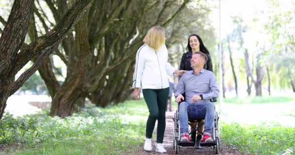 公園を歩いている若い女性と車椅子の男 障害者コンセプトへの支援 — ストック動画