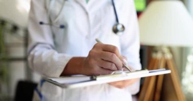 Doktor dosyanın üzerinde duruyor, yakın çekim, yavaş çekim. Hastanenin tıbbi kayıtları, sığ odak