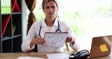 A question on paper is shown by a woman a doctor, a close-up, slowmotion. Medical competence, unknown disease